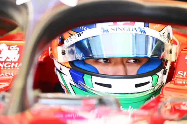 Zhou Guanyu sits in his Alfa Romeo F1 car, with his eyes visible through his visor.