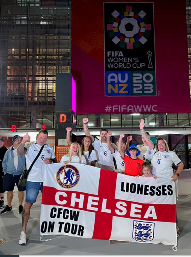 England fans pose with a banner for the Lionesses outside the stadium.