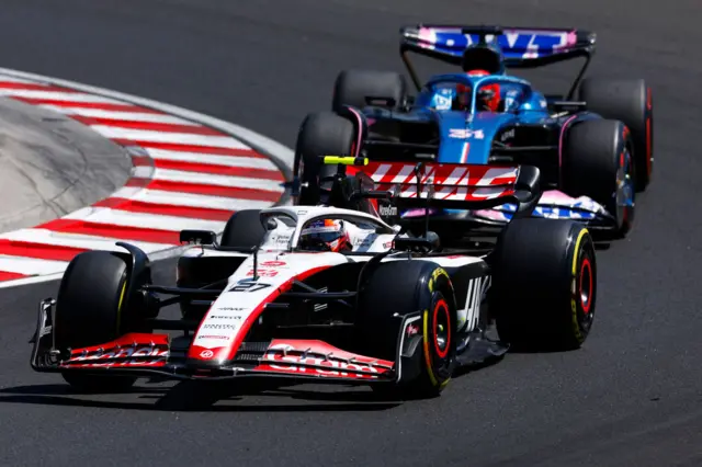 Nico Hulkenburg drives his Haas F1 car, closely followed by Ocon in the Alpine