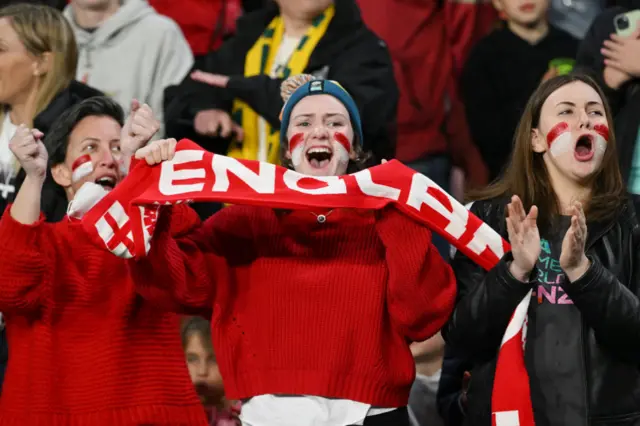 England fans shout support to the players from the stands.