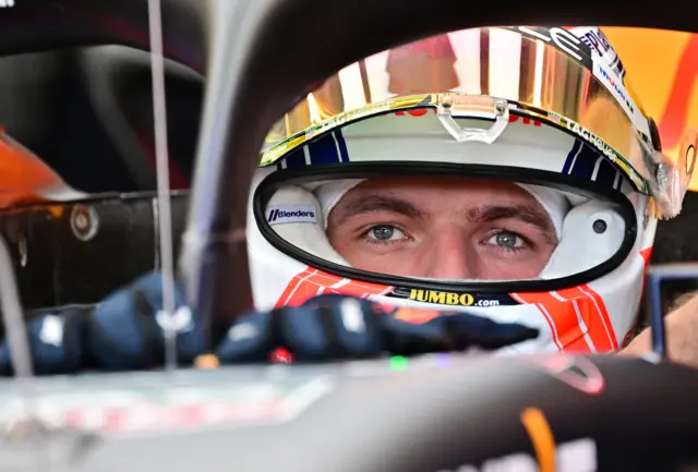 Close shot of Max Verstappen sitting in his F1 car, His eyes are visible through his visor.