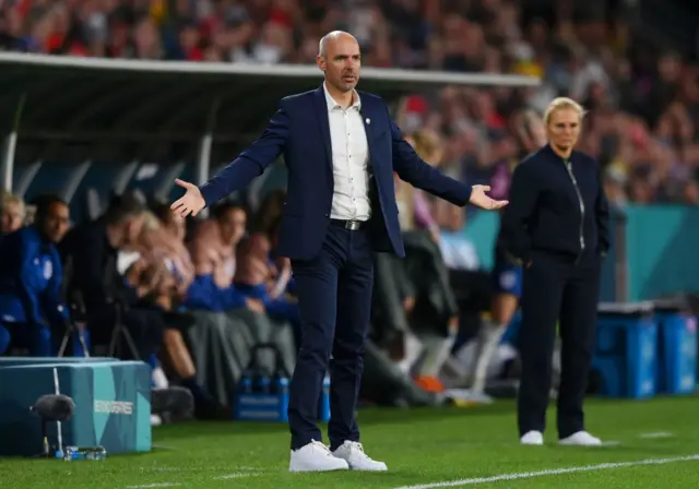 The Haiti manager looks on from the sideline confused at the referee.