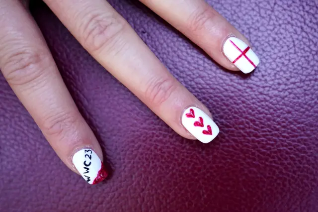 An England fan shows off their Lionesses-themed nail polish.