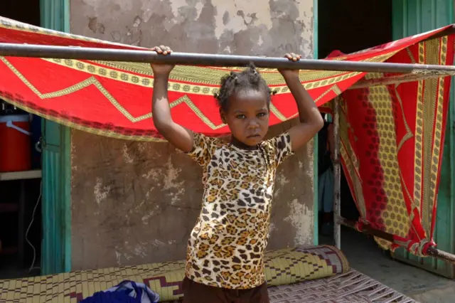 A displaced child at her makeshift home in a building courtyard in Khartoum.