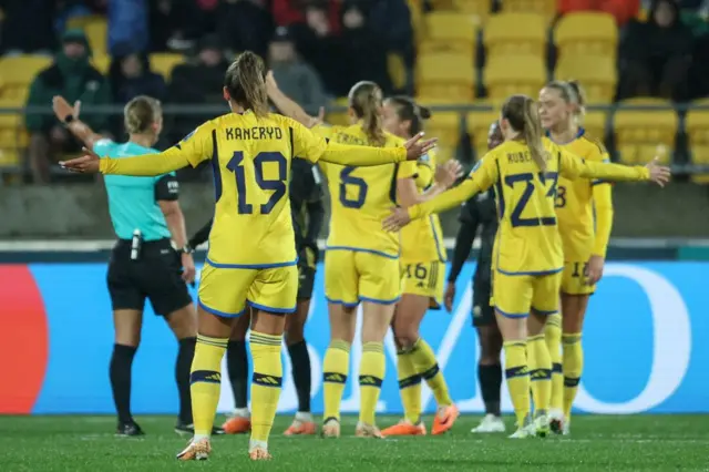 Sweden players protest for a penalty after the ball hit the arm of a defender.