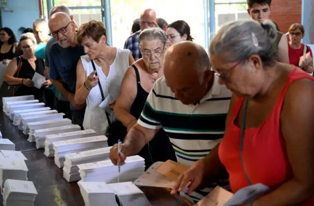 People choose their ballots at a polling station in Badalona