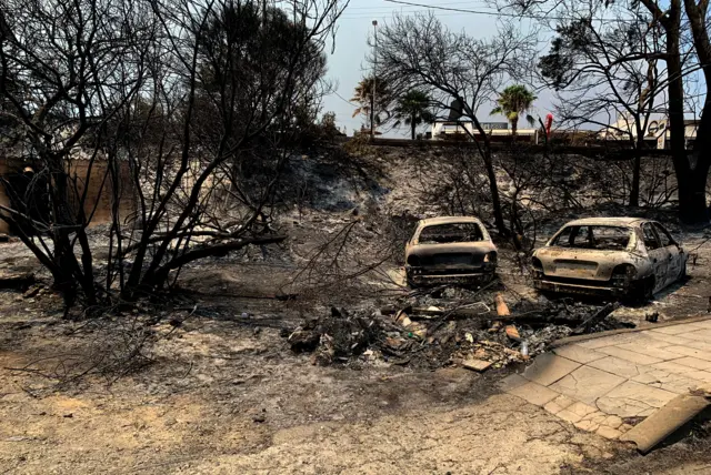 Burnt cars are seen after a wildfire in Kiotari village, on Rhodes island