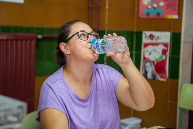 A member of a polling station drinks water during the general elections at a polling station on July 23, 2023, in Albacete, Castilla-La Mancha