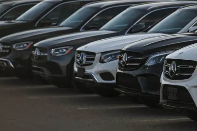 A fleet of luxury cars at a Mercedes-Benz dealership.