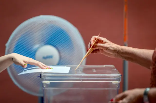 A woman casts her ballot during the general election at a polling station in Toledo