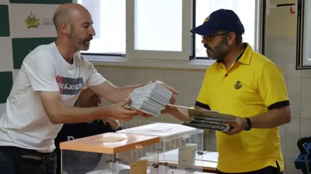 Postal votes are submitted at a polling station