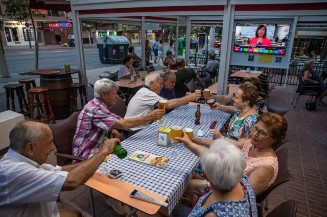 City center restaurant patrons dining as the first election polls are broadcast on television on July 23, 2023 in Benidorm, Spain