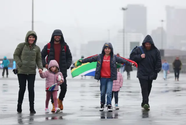 A young South Africa fan holds aloft a flag as he arrives at the stadium.