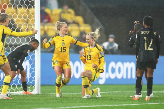 Sweden players roar in delight, South African players stand dejected.