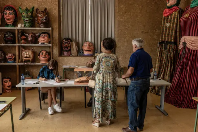 Residents queueing to cast their vote at a picturesque polling station in a rural area of Asturias