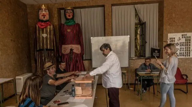 People queue to cast their vote at a polling station in a rural area of Asturias