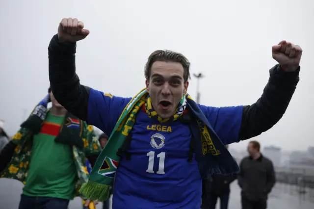 A South Africa fan raises his arms and cheers as he arrives for the match.