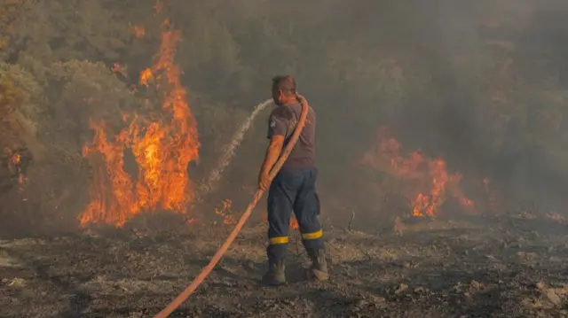 Firefighter tackles a blaze in Rhodes