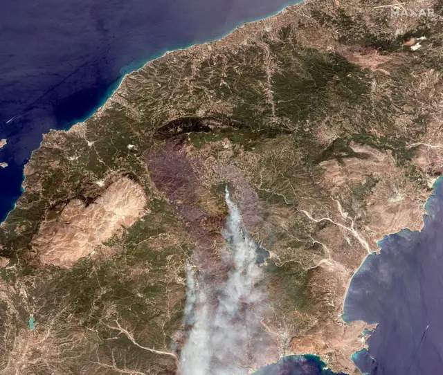 Satellite images show smoke billowing from the island of Rhodes