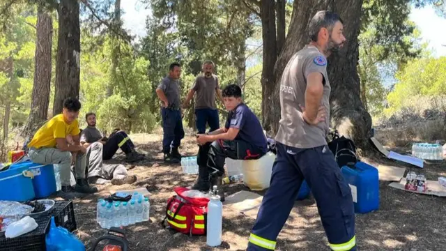 A group of volunteer firefighters camp near the woods that were burnt earlier this week in Salakos, Greece.