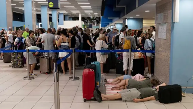 Evacuated tourists sleep inside the airport