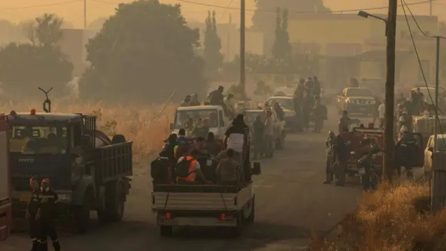 Locals prepare to tackle wildfires approaching the village of Masari, Rhodes