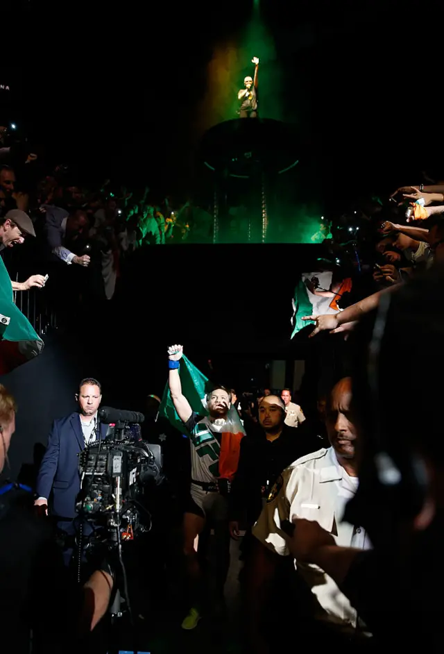 Singer Sinead O'Connor (top) performs as Conor McGregor walks to the Octagon to face Chad Mendes in their UFC interim featherweight title fight during the UFC 189 event inside MGM Grand Garden Arena on July 11, 2015 in Las Vegas, Nevada