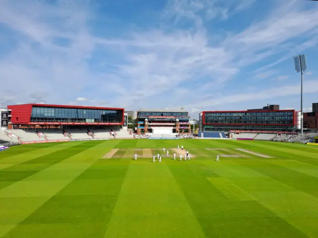 The players on the outfield at a sunny Old Trafford