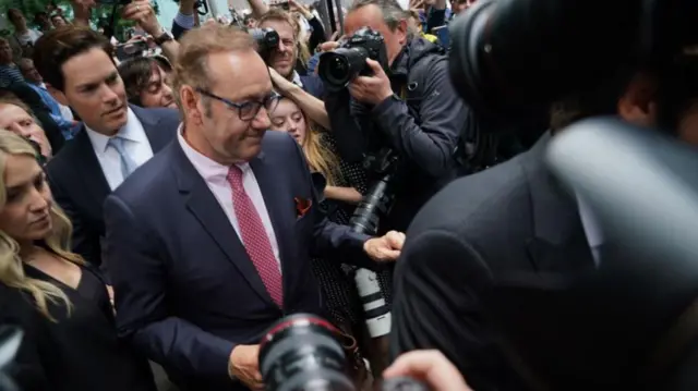 Actor Kevin Spacey surrounded by press outside Southwark Crown Court