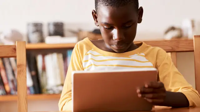 A boy using his tablet at home in South Africa