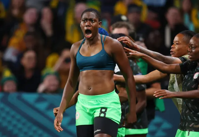 Oshoala screams in delight as she celebrates with teammates.