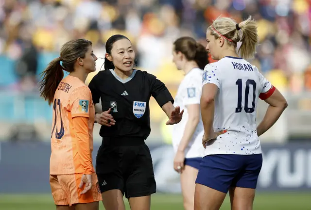 Referee Yoshimi Yamashita talks to Lindsey Horan of the U.S. and Netherlands' Danielle van de Donk