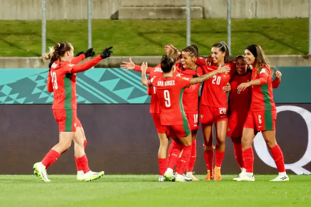 Portugal players huddle together to celebrate their second goal.