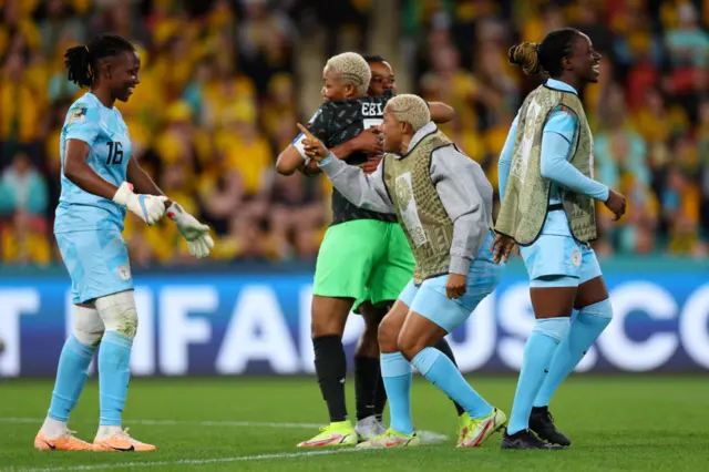 Nigeria players congratulate their keeper after her stellar performance.