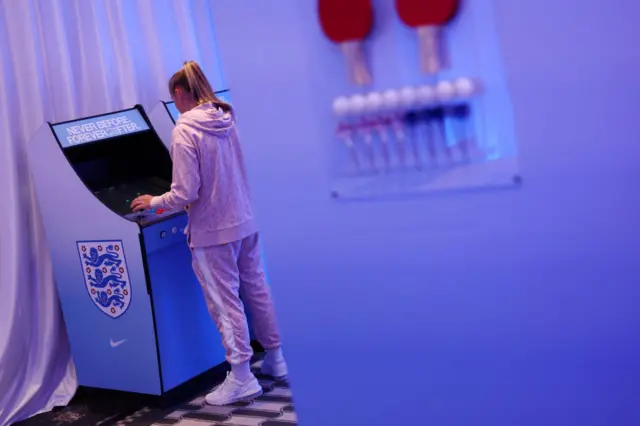 Georgia Stanway plays an arcade game at England's base camp.