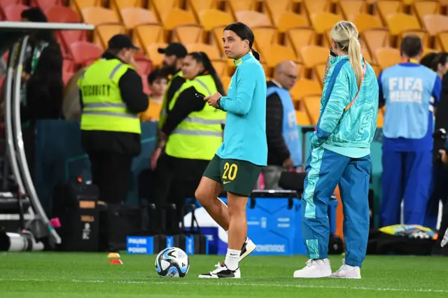 Sam Kerr surveys the stadium with her team mates from the pitch.