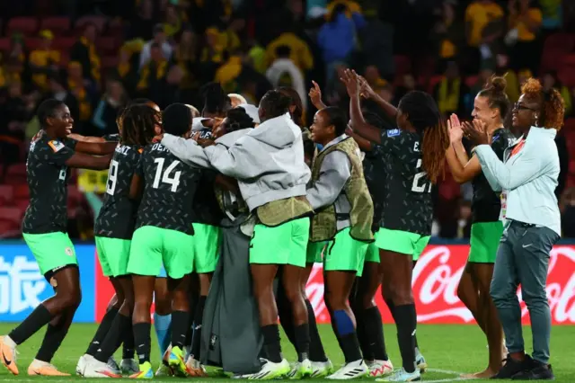 Nigeria players huddle together to celebrate their win.