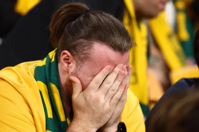 An Australia fan holds his head in his hands.