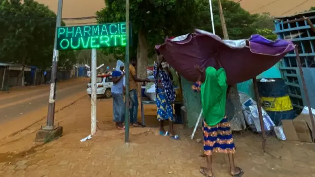 Street vendors set up their stall next to a road in Niamey, Niger - 27 July 2023