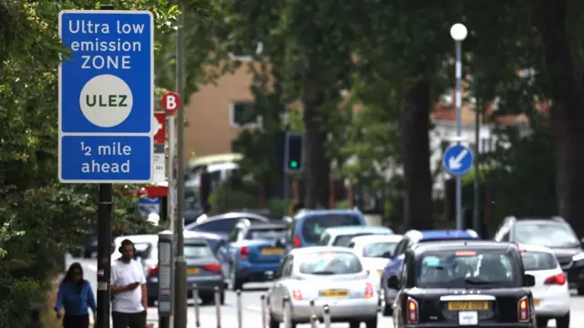 A Ulez sign on the side of a busy road