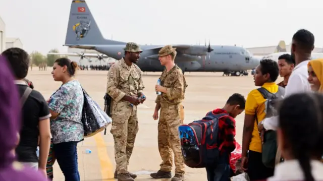 Duke of Lancaster's Regiment assist Egyptian citizens to their plane awaiting plane at Wadi Seidna Air Base on 28th April, 2023 in Omdurman, Sudan