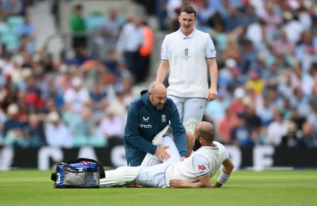 Moeen Ali getting treatment out in the middle after suffering a groin injury