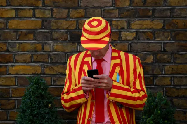 An ICC member checking his phone during a lunch break at Lord's