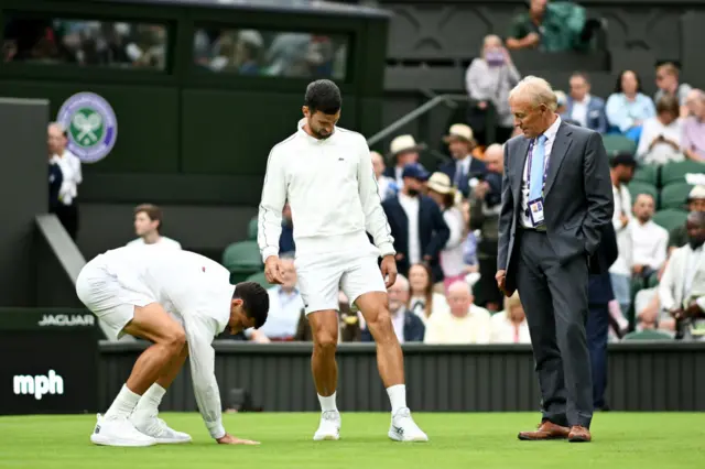 Djokovic inspects the grass