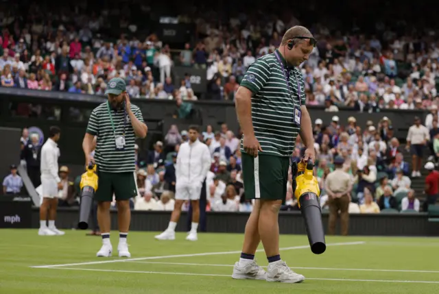 Ground staff try to dry Centre Court