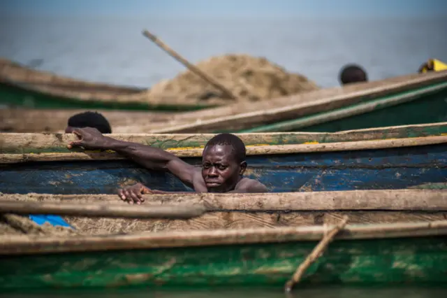 A man is seen between boats on the Lake Victoria at Nyamware village in Kisumu, Kenya on June 23, 2023.