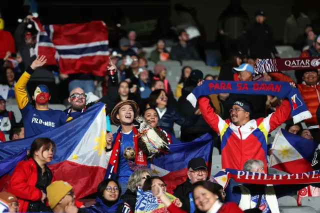 Philippines fans hold scarves in the air to suppor their team.