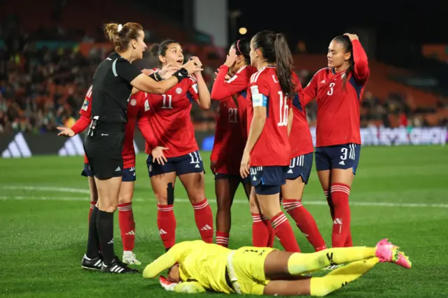 Musonda lies on the floor after colliding with an opponent, Costa Rica players claim for a penalty.