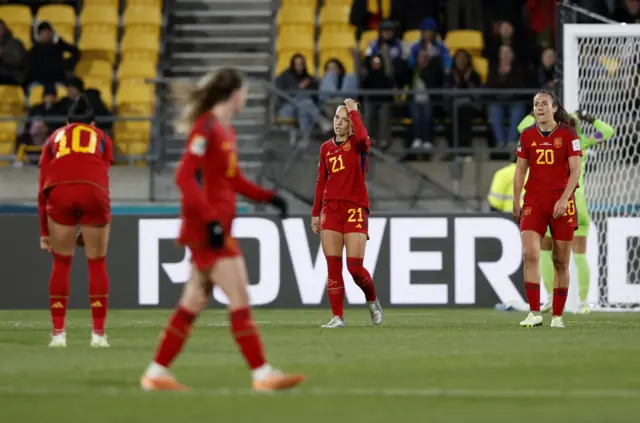 Spain players stand with heads in hands after conceding a fourth.