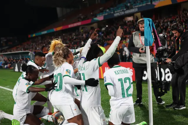 Zambia players celebrate at the corner flag after their second goal.